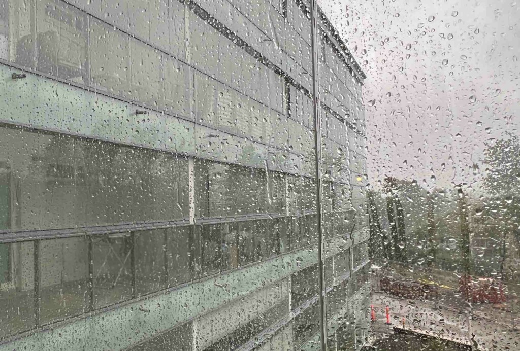 Kovat sateet lisääntyvät ilmastonmuutoksen myötä, ja sade kurittaa rakennuksia. Kuvassa sateen kastelema parvekelasitus, taustalla näkyy asuinkerrostaloa. Ilmastoriskiselvitys huomioi mm. muutokset sateessa.